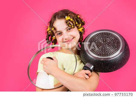 Perfect for pancakes. Small girl with curlers in hair. Pin up style. Culinary and house duties. Girl hold Frying Pan. Little kid hold pan cooking meal. Home utensils. Kitchen accessory. Healthy food 97733170