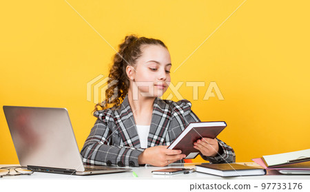 lets read book. schoolgirl has online homework. back to school. time to study. small girl in office. little businesswoman. happy childhood. kid with curly hair wear jacket. work on laptop 97733176