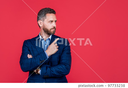 mature ambitious man businessman in businesslike suit pointing finger on copy space, suggestion mature ambitious man businessman in businesslike suit pointing finger on copy space, suggestion 97733238