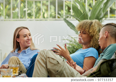 Emotional young woman gesturing when telling story to friends at party Emotional young woman gesturing when telling story to friends at party 97733357
