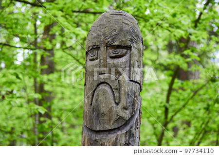 The image of the Slavic deity Veles carved from a tree trunk on a neo-Pagan temple in the forest 97734110