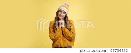 Touched charming cute silly young girl make flirty gazes camera press palms together checking out something moving cute, tilting head seeing adorable kitten, smiling delighted yellow background 97734552