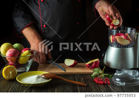 The chef adds apples to the blender to make a fruit drink. Healthy vegetarian breakfast idea 97735053