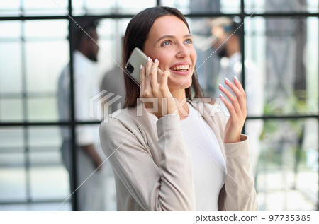 Businesswoman with phone in modern office 97735385