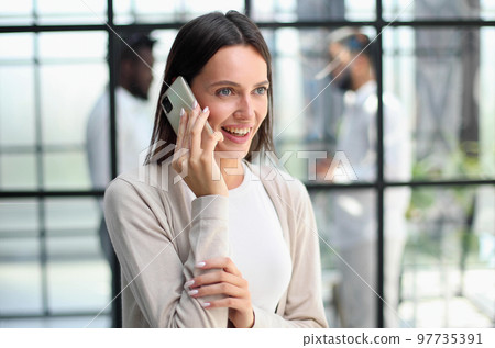 Businesswoman with phone in modern office Businesswoman with phone in modern office 97735391