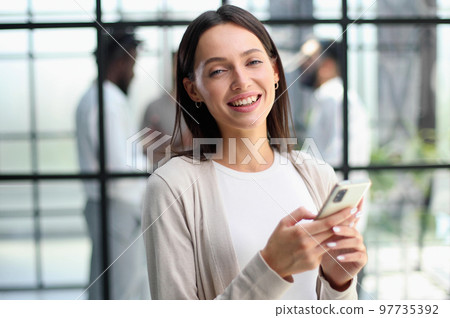 Businesswoman with phone in modern office 97735392