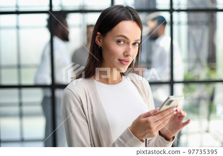 Businesswoman with phone in modern office 97735395