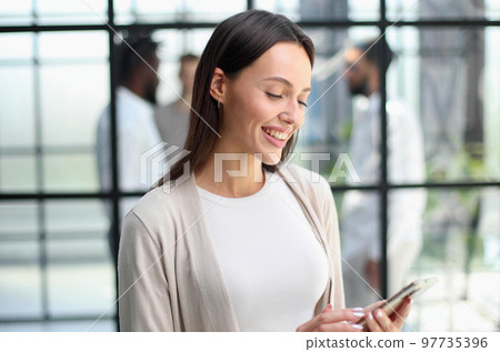 Businesswoman with phone in modern office 97735396