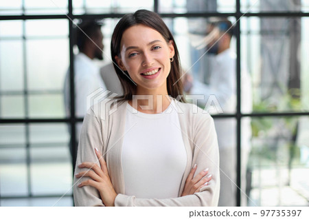 business woman with her staff in background at office 97735397