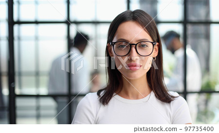 business woman with her staff in background at office 97735400