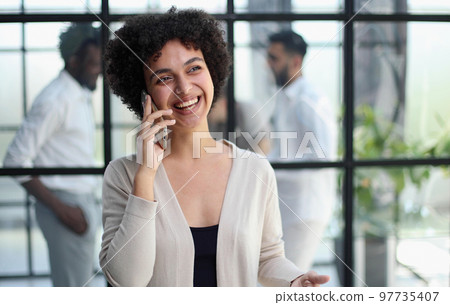 Businesswoman with phone in modern office 97735407