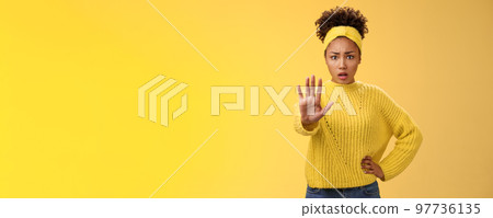 Afraid shocked insecure woman trying show voice be brave extend arm enough stop refusal gesture look frightened insecure unconfident rejecting declining offensive proposal, yellow background 97736135