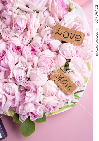 plate of pink fresh fragrance roses with " love you" sign around double pink background. romantic and beauty concept . flat lay plate of pink fresh fragrance roses with " love you" sign around double pink background. romantic and beauty concept . flat lay 97736422