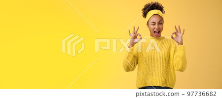 Okay I got it. Cute reliable truthful african-american girlfriend assuring friend secret safe winking devious hinting work done okay show ok fine perfect gesture no worry about, yellow background 97736682