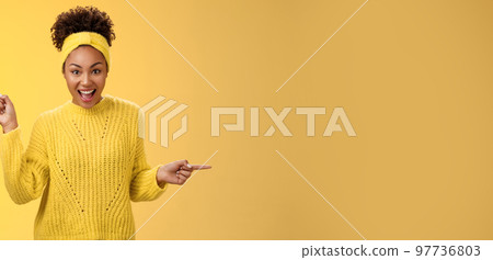 Energized active charismatic african-american woman afro hairstyle in sweater headband screaming fascinated enthusiastic pointing left right impressed variaty awesome choices, picking products 97736803
