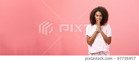 Creative and smart stylish attractive african american woman with curly hairstyle having great plan or idea feeling ambitious holding hands in pray over mouth gazing thoughtful at camera Creative and smart stylish attractive african american woman with curly hairstyle having great plan or idea feeling ambitious holding hands in pray over mouth gazing thoughtful at camera 97736957
