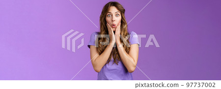 Impressed surprised attractive enthusiastic girlfriend hear shocking impressive rumor gasping fold lips wow gossiping touch cheeks ambushed stand purple background curious 97737002