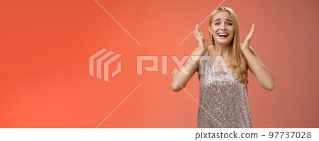 Amazed freaked out excited blond female fan see favorite celebrity star screaming astonished happy look emotive wanna cry happiness waving palms near head thrilled red background 97737028