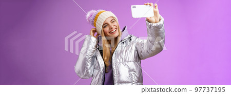 Joyful carefree charming blond girl having fun wanna post pictures from ski resort vacation taking seflie holding smartphone mimicking show tongue winking look mobile display, purple background Joyful carefree charming blond girl having fun wanna post pictures from ski resort vacation taking seflie holding smartphone mimicking show tongue winking look mobile display, purple background 97737195