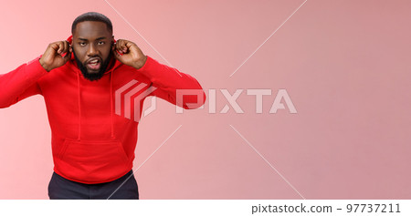 Annoyed funny irritated young african-american bearded guy bending forward close ears plug index fingers grimacing fed up hear loud awful noise repairment works standing bothered lose temper Annoyed funny irritated young african-american bearded guy bending forward close ears plug index fingers grimacing fed up hear loud awful noise repairment works standing bothered lose temper 97737211