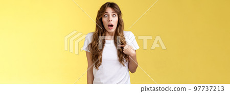 You mean me. Surprised questioned impressed gasping cute girl pointing herself indicating chest open mouth ambushed being picked chosen asking if person talking her stand yellow background 97737213
