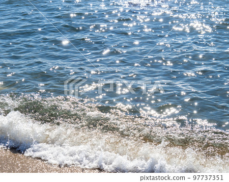 A beautiful blue sea that reflects the sunlight and sparkles. 97737351