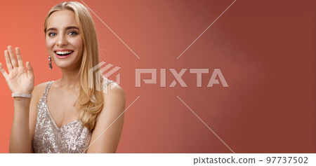 Waist-up studio shot friendly attractive elegant tender blond woman say hi waving raised hand greeting welcoming friend smiling delighted introducing herself hello gesture, red background Waist-up studio shot friendly attractive elegant tender blond woman say hi waving raised hand greeting welcoming friend smiling delighted introducing herself hello gesture, red background 97737502