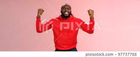 Happy thankful young african american bearded man thank god for son close eyes joyfully smiling clench fists celebrating triumphing dream come true accomplish goal, cheering victory 97737788