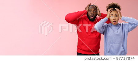 Shocked worried african american couple man woman holding hands head panicking widen eyes stunned receive bad concerning news feel troubled nervous, standing pink background anxious Shocked worried african american couple man woman holding hands head panicking widen eyes stunned receive bad concerning news feel troubled nervous, standing pink background anxious 97737874