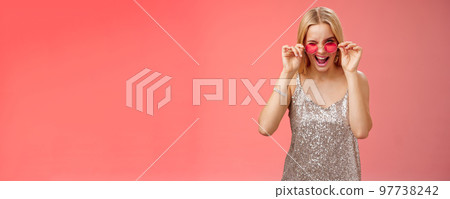 Sassy carefree daring young blond girl winking cheeky smiling assertive making first move approach handsome man nightclub asking dance standing red background touching sunglasses wear dress Sassy carefree daring young blond girl winking cheeky smiling assertive making first move approach handsome man nightclub asking dance standing red background touching sunglasses wear dress 97738242