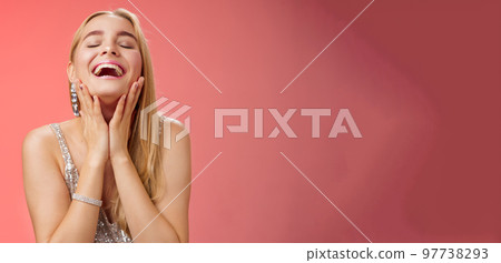 Waist-up joyful accomplished charming rich blond woman in silver stylish evening dress touching cheeks happily smiling laughign carefree close eyes tender have fun relaxing party dance floor 97738293