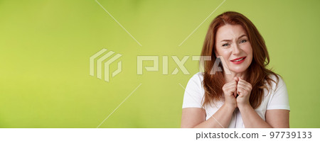 Silly touched tender redhead charmed middle-aged woman sighing gladly gaze admiration delighted press hands together heartwarmed fascinated look grateful lovely camera green background Silly touched tender redhead charmed middle-aged woman sighing gladly gaze admiration delighted press hands together heartwarmed fascinated look grateful lovely camera green background 97739133