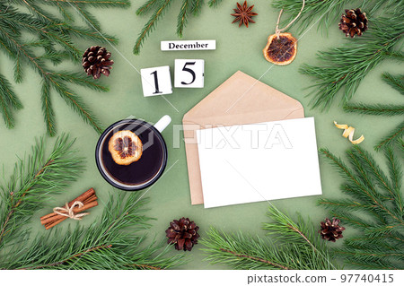 December 15. Calendar date, white blank with craft envelope, cup of tea and natural decor on green background. Hello winter. Template for your design, greeting card December 15. Calendar date, white blank with craft envelope, cup of tea and natural decor on green background. Hello winter. Template for your design, greeting card 97740415