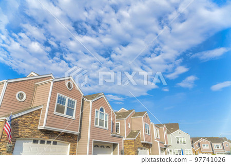 Low angle view of a townhouses exterior with pink vinyl wood and stone veneer sidings at California 97741026