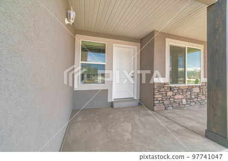 Front door exterior of a house with two windows and wall lamp lighting Front door exterior of a house with two windows and wall lamp lighting 97741047