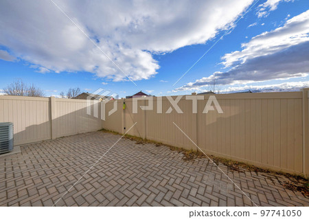Vinyl fence of a backyard with bricks in herringbone pattern 97741050