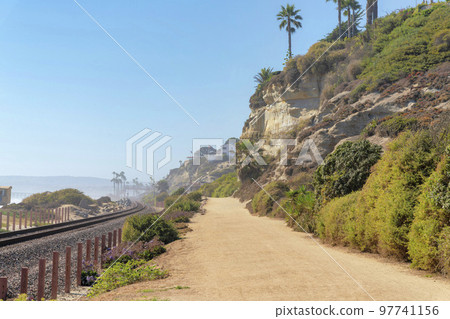 Train track and dirt road at the beach of San Clemente, California 97741156