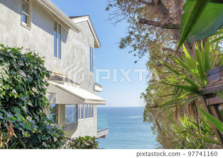 Outside a multi-storey beach house at San Clemente, California with a view of the blue sea 97741160