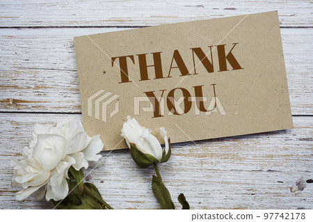 Thank You text message on paper card with flower decoration on wooden background Thank You text message on paper card with flower decoration on wooden background 97742178