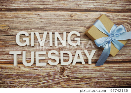 Giving Tuesday alphabet letters and gift box on wooden background Giving Tuesday alphabet letters and gift box on wooden background 97742186