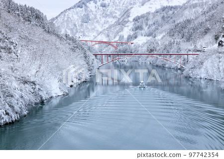 Toyama _ Scenic view of the sightseeing boat going through the snowy Shogawa Gorge 97742354