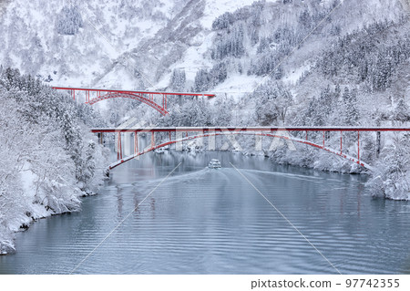 Toyama _ Scenic view of the sightseeing boat going through the snowy Shogawa Gorge 97742355