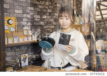 Young woman shopping at a general store 97743010