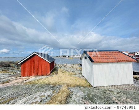 A view of red wooden houses on Vrango Archipelago island . A view of red wooden houses on Vrango Archipelago island . 97745991