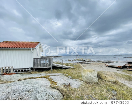 A view of red wooden houses on Vrango Archipelago island . A view of red wooden houses on Vrango Archipelago island . 97745993