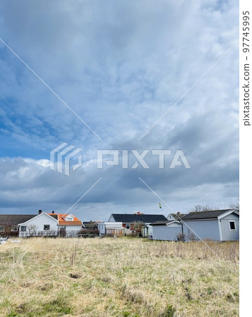 A view of red wooden houses on Vrango Archipelago island . A view of red wooden houses on Vrango Archipelago island . 97745995