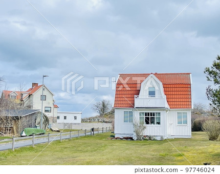 A view of red wooden houses on Vrango Archipelago island . 97746024