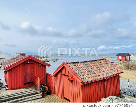 A view of red wooden houses on Vrango Archipelago island . A view of red wooden houses on Vrango Archipelago island . 97746054