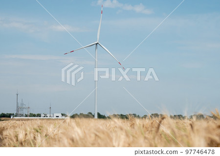 Ecofriendly wind turbine produces clean energy on field 97746478