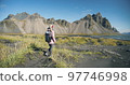 Morning scene of female traveler exploring Stokksnes cape with Vestrahorn on background Sunny summer day in Iceland 97746998